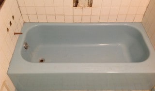 Bathroom remodeling before ugly blue tub and damaged tile wall