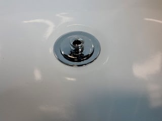 Bathtub drain rust hole repair with new chrome drain installed.