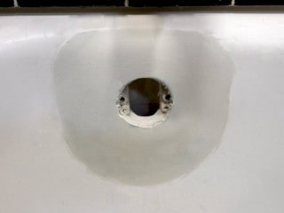 Bathtub overflow rust hole repair completed.