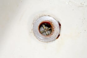 Old tub drain with rust forming around and underneath which would look awful if not replaced.