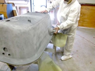 Sanding the exterior of the clawfoot smooth.