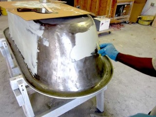 Polyester filler being applied to casting defects.