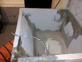 Damaged laundry room concrete sink being repaired.
