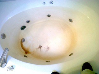 Damaged jacuzzi bathtub before being refinished.