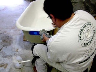 Technician doing body work on clawfoot tub.